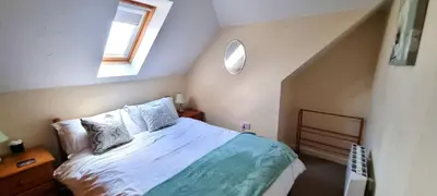 a bedroom with a bed and a window at Sand Dunes in Perranporth
