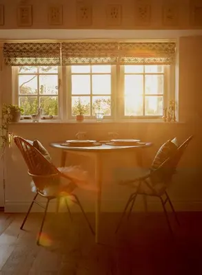 a table and two chairs in a room with windows at Poachers Pocket Cottage in Bodmin