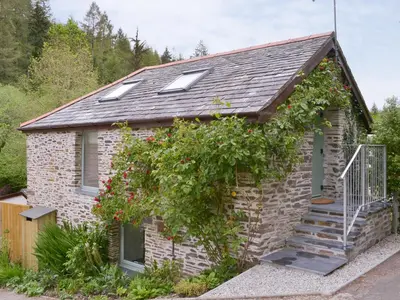 a small brick house with a staircase in front of it at Ladyvale Barn in Cardinham
