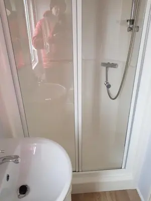 a man taking a picture of a shower in a bathroom at Caravan Willerby Rio in Looe