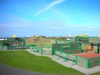 a baseball field with benches in the grass at Chalet 151, Perran Sands in Perranporth