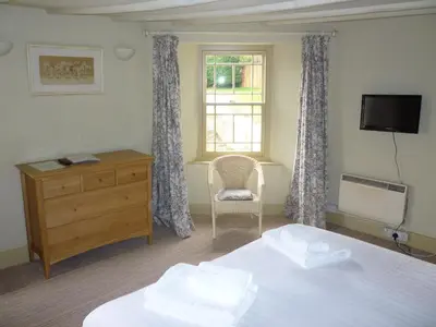 a bedroom with a bed and a dresser and a window at Royal Oak Inn in Lostwithiel