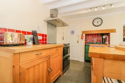 a kitchen with a counter and a clock on the wall at 1 Dormer Villas in Porthscatho
