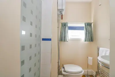 a bathroom with a toilet and a sink at 1 Dormer Villas in Porthscatho