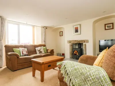 a living room with a couch and a fireplace at Withan Farm Wing in Manaccan