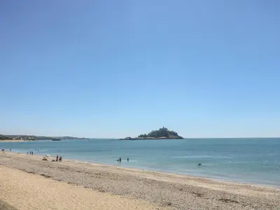 a beach with a group of people in the water at Seabreeze in Marazion