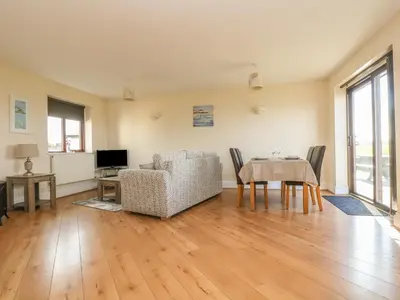 a living room with a table and a chair at Seabreeze in Marazion
