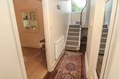 a hallway with a staircase and a rug at Banneth in Mawgan
