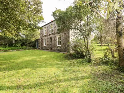 an old stone house with a large yard at Banneth in Mawgan