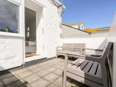 a balcony with a bench and a bed in a room at Porthmeor Beach House in St Ives