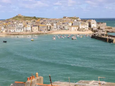 a group of boats in the water near a beach at Porthmeor Beach House in St Ives