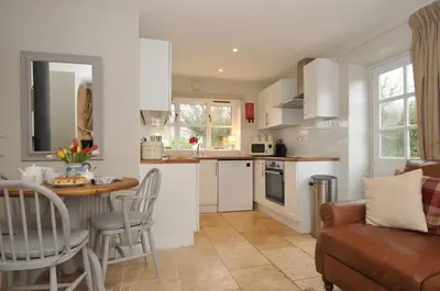 a kitchen and living room with a table and chairs at Stocks Barn in Liskeard