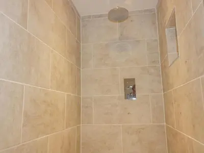 a bathroom with a shower with a tiled shower at The Beach Halt in Perranporth