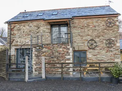 a brick building with a balcony on the side of it at The Cart House in Liskeard