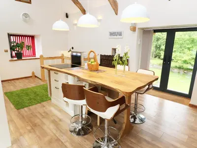 a kitchen with a wooden table and chairs at The Cart House in Liskeard