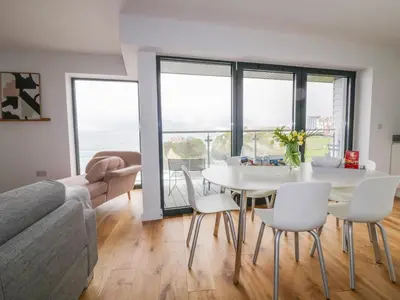 a living room with a white table and chairs at Onshore 7 in Newquay