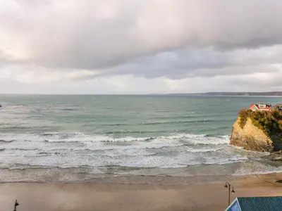 a view of the ocean with a house on a cliff at Onshore 7 in Newquay