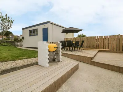 a backyard with a house and a wooden deck at Dune Haven in Truro