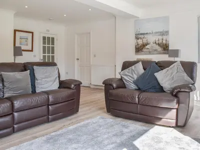 a living room with two brown leather couches and a rug at Caddie - Uk11038 in Carlyon Bay