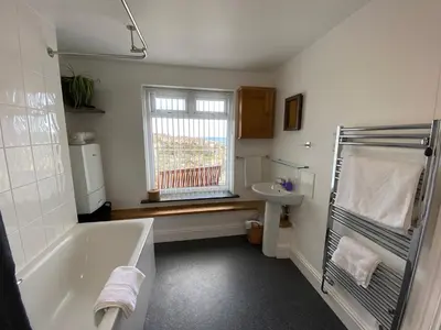 a bathroom with a tub and a sink at THE PENTHOUSE Top Floor Apartment with Bay Views, Large Balcony & Onsite Parking in St Ives