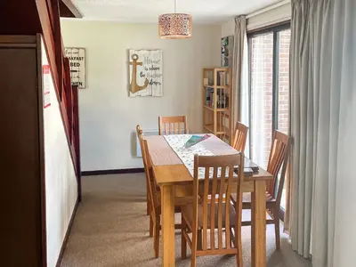 a dining room with a wooden table and chairs at Trevithick Lodge in Hayle