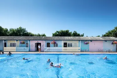 a group of people swimming in a swimming pool at Buller Cottage in Cornwall in Newquay