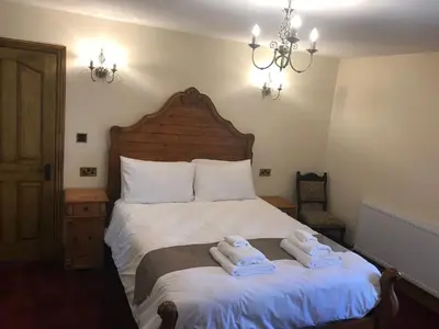 a bedroom with a bed with two towels on it at Great Trethew Manor Hotel & Restaurant in Menheniot
