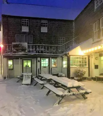 a group of tables in the snow in front of a building at The Darlington Hotel in Camelford