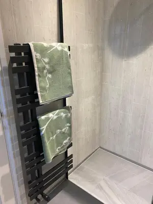 a shower with green towels on a rack in a bathroom at Downsfield Bed and Breakfast in St Ives