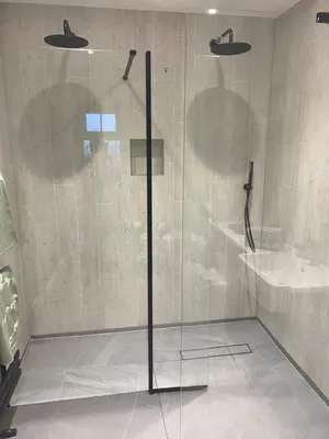 a shower with a glass door in a bathroom at Downsfield Bed and Breakfast in St Ives