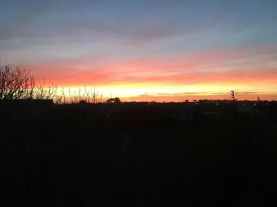 a sunset with the sun setting in the sky at The Byre in Porthtowan