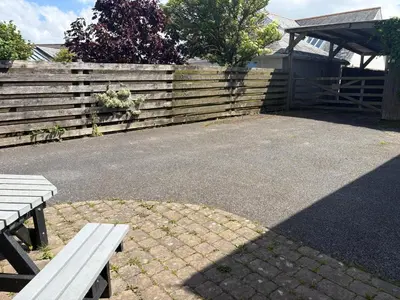 a wooden fence with a bench in front of it at The Byre in Porthtowan