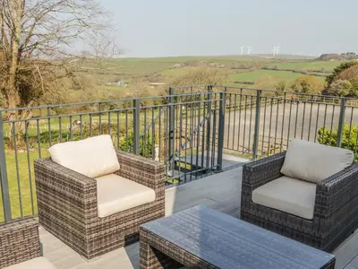 two chairs and a table on a balcony at The Coach House in Saint Columb Major