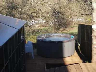 a large hot tub on a deck with a chair at So Tranquil in Charlestown