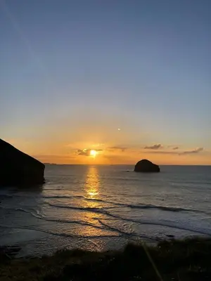a sunset over the ocean with the sun setting at Buena Vista in Tintagel