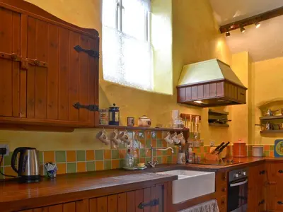 a kitchen with wooden cabinets and a sink and a window at Provence-Uk12747 in Menheniot