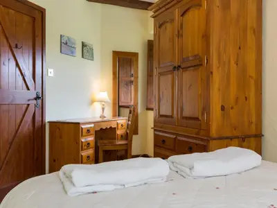 a bedroom with a bed and a wooden cabinet and a dresser at Provence-Uk12747 in Menheniot