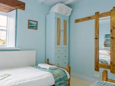 a blue bedroom with two beds and a mirror at New England-Uk12750 in Menheniot