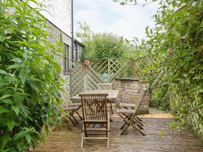 a wooden table and chairs on a wooden deck at New England-Uk12750 in Menheniot