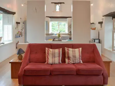 a living room with a red couch with two pillows at Moderno-Uk12748 in Menheniot
