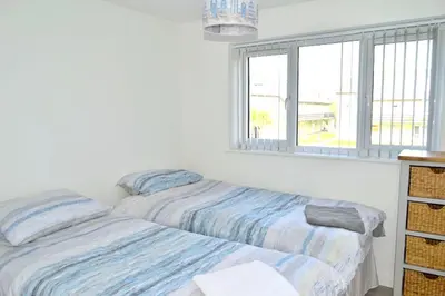 two beds in a room with a window at 2 Rosemullion in Perranporth
