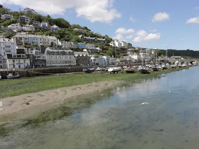 a body of water with a bunch of houses and boats at Harbour View Apartment in Looe