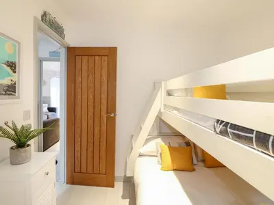 a room with a staircase with yellow pillows at Offshore in Porthtowan