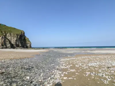 a beach with rocks and the ocean in the background at Offshore in Porthtowan
