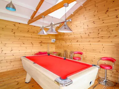 a pool table in a room with wooden walls at Forget-me-not in Saint Columb Major