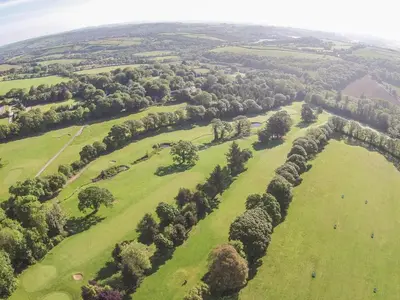 an aerial view of a green field with trees at Beech in Truro
