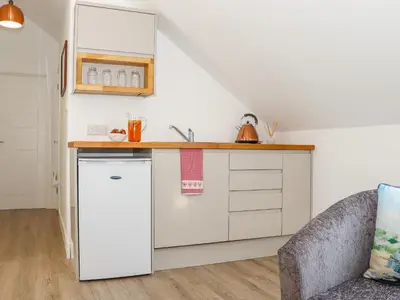 a kitchen with white cabinets and a counter top at The Crest in Helston