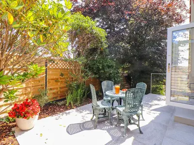 a patio with a table and chairs and a fence at The Crest in Helston