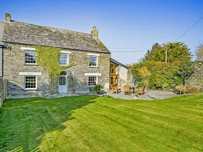 an old stone house with a grass yard at The Old Farmhouse-Uk12895 in Pelynt