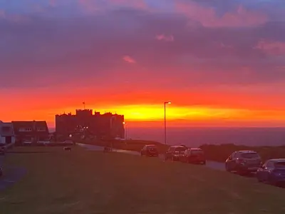 a sunset with cars parked in a parking lot at Copthorne - Tintagel in Tintagel